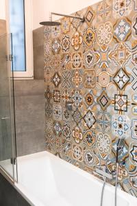 a bathroom with a shower with a tile wall at WONDER CRACOW in Krakow +21 photos