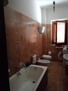 y baño con bañera, aseo y lavamanos. en Casa Staropoli, en Sciconi