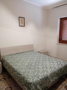 um quarto com uma cama num quarto branco em Casa Staropoli em Sciconi