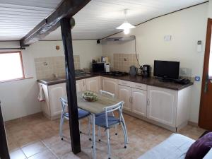 eine Küche mit einem Tisch und Stühlen im Zimmer in der Unterkunft Gîte Pouton in Saint-Loubouer