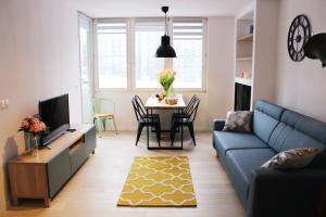 salon z niebieską kanapą i stołem w obiekcie Comfy with great city view by Cooee Apartments w Warszawie