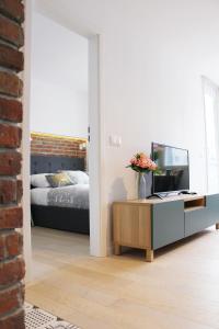 ein Wohnzimmer mit einem TV auf einem Schrank und einem Bett in der Unterkunft Comfy with great city view by Cooee Apartments in Warschau