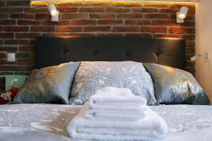 ein Bett mit einem Haufen weißer Handtücher drauf in der Unterkunft Comfy with great city view by Cooee Apartments in Warschau