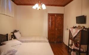 A bed or beds in a room at Under the Clock Tower (Greek Traditional 125m2 home)