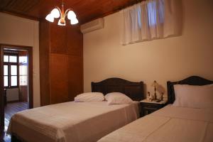 A bed or beds in a room at Under the Clock Tower (Greek Traditional 125m2 home)