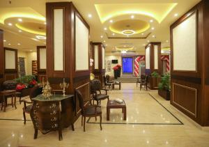 a lobby with chairs and tables in a building at Horizon Shahrazad Hotel in Cairo