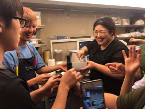 a group of people holding up their cell phones at Kinnon Deluxe Hostel Coworking Cafe in Bangkok