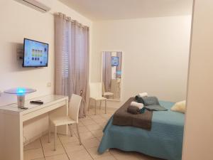 um quarto com uma cama, uma secretária e uma televisão em Naxian holidays em Giardini Naxos