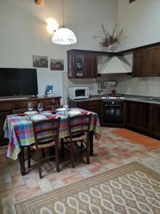 a kitchen with a table with chairs and a tv at Agriturismo Tre Madonne in Monteriggioni