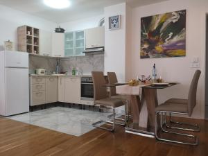a kitchen with white cabinets and a table and chairs at DAVID-IN 2 in Zagreb