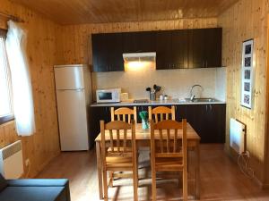 uma cozinha com uma mesa e cadeiras e um frigorífico em Aire Turismo Rural em Uña