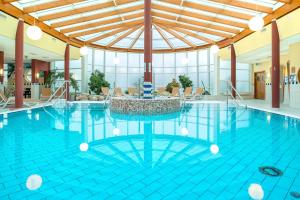 a large pool with a table in the middle at Dünenhaus mit Schwimmbadnutzung in Göhren +18 photos