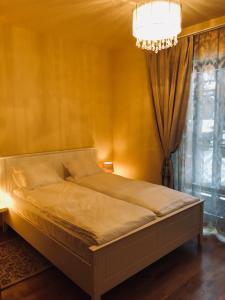 a bed in a bedroom with a chandelier at 365 in Jūrmala