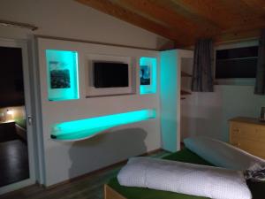 sypialnia z niebieskimi światłami na ścianie w obiekcie Oberrollerhof w mieście Virgen