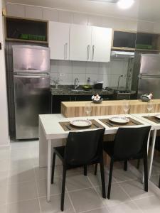uma cozinha com uma mesa e cadeiras e um frigorífico em Apartamentos Praia de Pajucara em Maceió