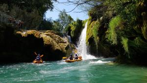 a group of people on rafts in a waterfall at Hotel Mirjana & Rastoke in Slunj