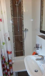 biała łazienka z prysznicem i umywalką w obiekcie Appartement Ferienwohnung Vogel w mieście Hilchenbach