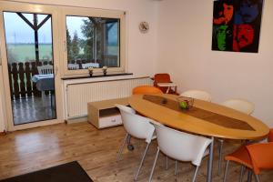 a dining room with a wooden table and chairs at Drei Linden Fümmelse in Wolfenbüttel