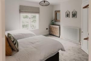 een slaapkamer met 2 bedden, een dressoir en een raam bij Penny Black Cottage in Coalbrookdale