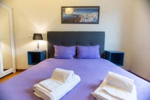 ポルトにあるEnjoy Porto Apartment by Porto City Hostsのベッドルーム1室(紫色のベッド1台、タオル2枚付)