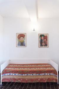 a bed in a room with two pictures on the wall at Residence Capobianco in Portoferraio