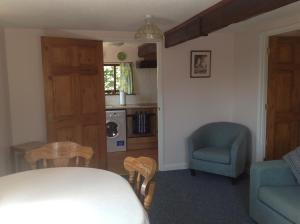a living room with a table and a chair at New Stable Cottage in Cowes