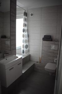 La salle de bains est pourvue d'un lavabo, de toilettes et d'une fenêtre. dans l'établissement Bruno Apartment, à Cluj-Napoca