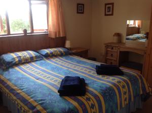 a bedroom with a bed with two bags on it at New Stable Cottage in Cowes