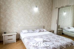 a bedroom with a bed and a wall with wallpaper at Tbilisi Comfort Apartment in Tbilisi City