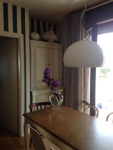 una mesa de comedor con un jarrón de flores púrpuras. en LA CASA DEL MARE en Fano