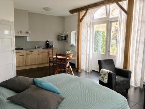 a bedroom with a bed and a table and a kitchen at De Borg Vakantie Appartementen in Winterswijk