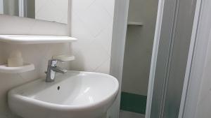 a bathroom with a white sink and a mirror at Residence Capobianco in Portoferraio