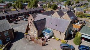 uma vista aérea de uma grande casa de tijolos com uma garagem em The Old School House em Haltwhistle