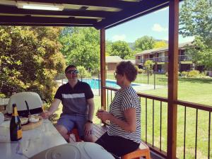 a man and a woman sitting on a porch at Motel Sierra - Bright in Bright