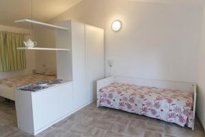 a small bedroom with a bed and a cabinet at Residence Capobianco in Portoferraio
