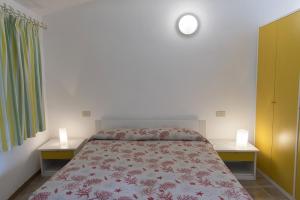 a bedroom with a bed with two tables and two lamps at Residence Capobianco in Portoferraio