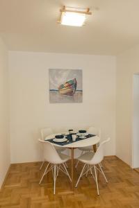 een eetkamer met een tafel en stoelen en een schilderij bij Apartmani Hemera in Valjevo