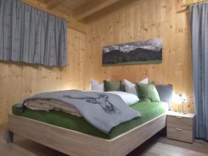 sypialnia z łóżkiem w drewnianej ścianie w obiekcie Oberrollerhof w mieście Virgen