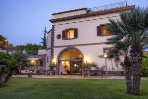 a house with a palm tree in a yard at Amore Rentals - Residence Bosco in SantʼAgata sui Due Golfi