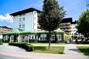 un grande edificio bianco con un albero di fronte di Holzapfel a Bad Füssing