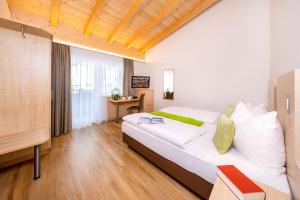 a bedroom with a bed and a desk in a room at Hotel-Restaurant Lampenhäusl in Fusch an der Glocknerstraße