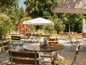 um grupo de mesas e cadeiras com um parque infantil em Alter Wirt Thalkirchen em Munique