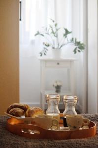 ein Tablett mit Kaffeetassen und Brot auf dem Tisch in der Unterkunft Punto8 in Triest