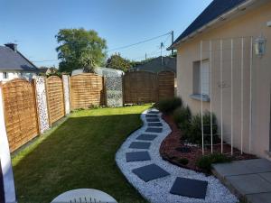 a small backyard with a fence and a walkway at Gite d' angel in Kermaria-Sulard