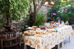 una mesa con comida en un jardín en B&B L'Albero Dei Limoni, en Portoscuso