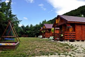a log cabin with a playground in front of it at Acapulco Domki Radków in Wünschelburg