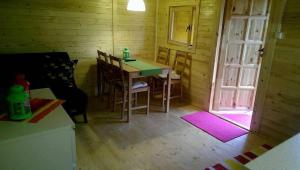 een kamer met een tafel en stoelen en een deur bij Acapulco Domki Radków in Radków