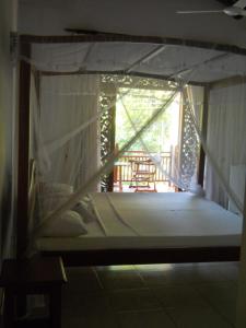 a canopy bed in a room with a porch at Villa Wunderschön in Bentota