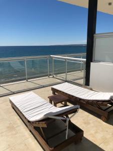 a balcony with two beds and a table on a ship at "Ninfas" in Puerto Madryn