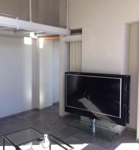 TV de pantalla plana grande en la sala de estar. en Horse Shoe House, en Chiaverano